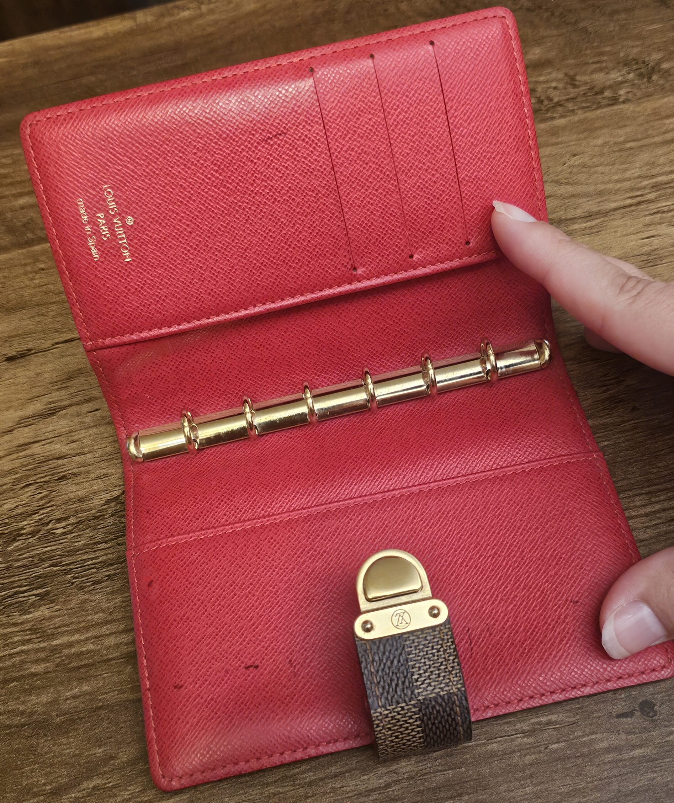 Agenda opened to show the six-ring mechanism and card slots in red leather