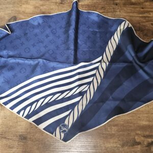 Scarf folded into a triangle showing the Monogram and stripes