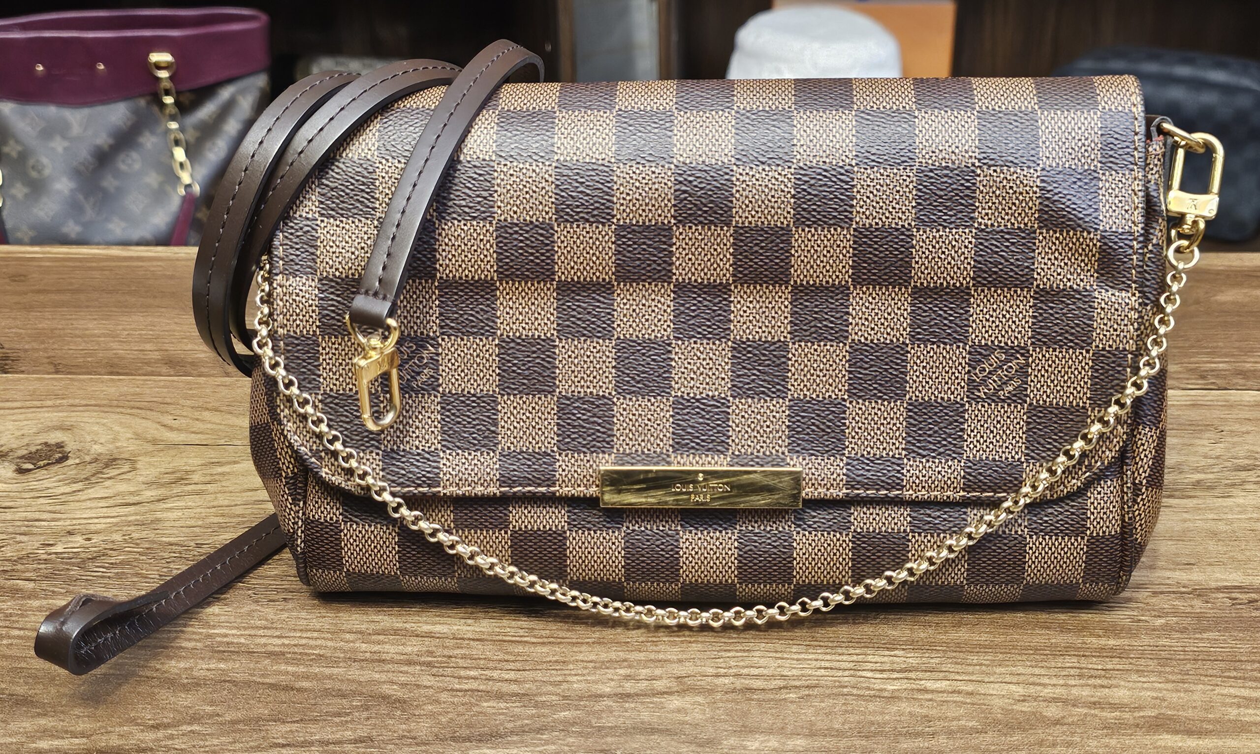 Louis Vuitton Damier Ebene Favorite MM - the bag with its brown leather strap and gold-tone chain