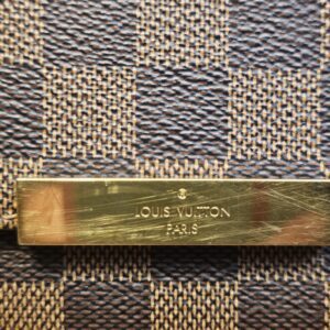 Gold-tone plate engraved LOUIS VUITTON PARIS, showing scratches
