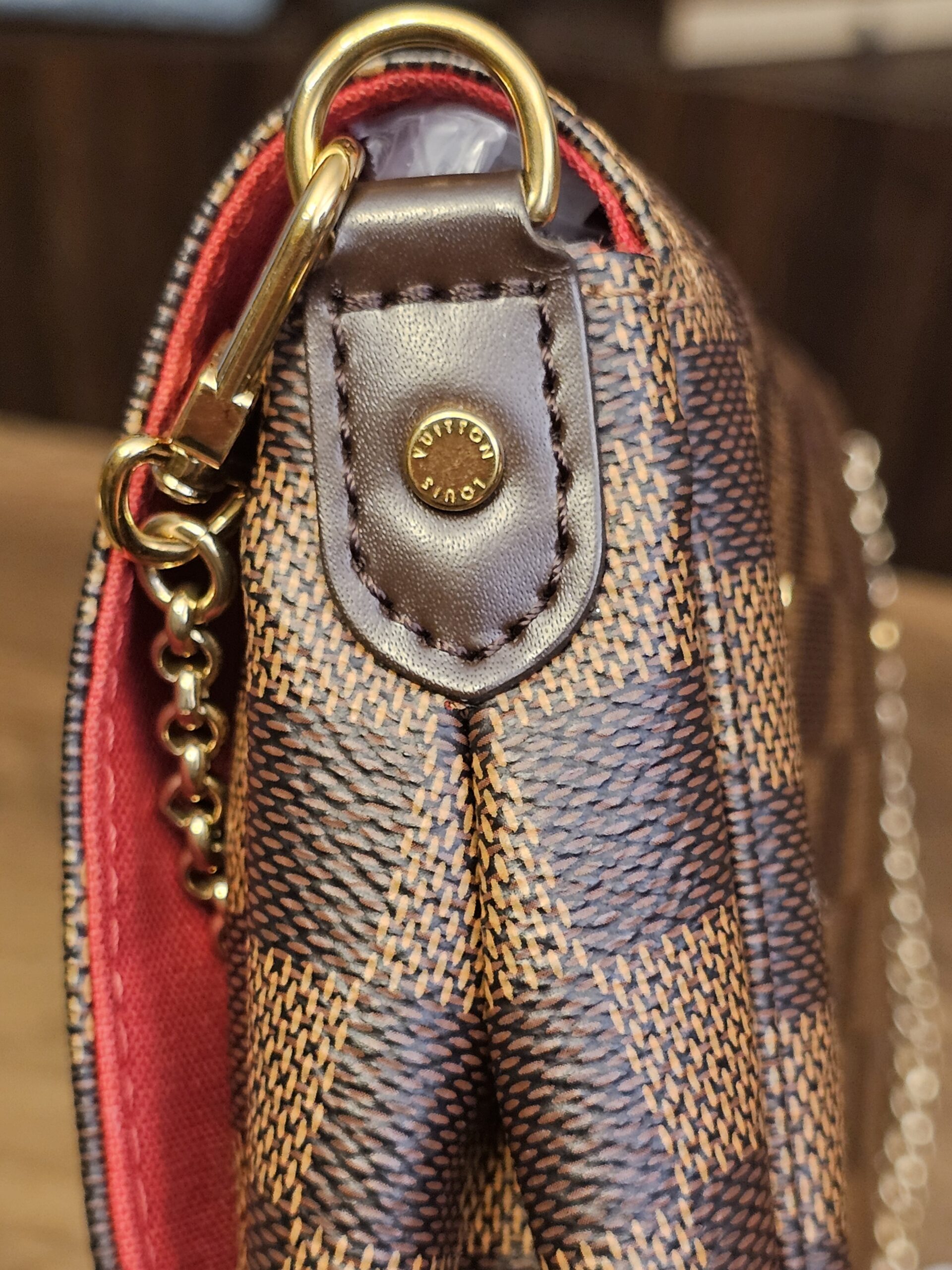 Gold-tone chain clipped to the side D-ring