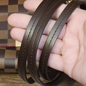 Removable brown leather strap held in hand