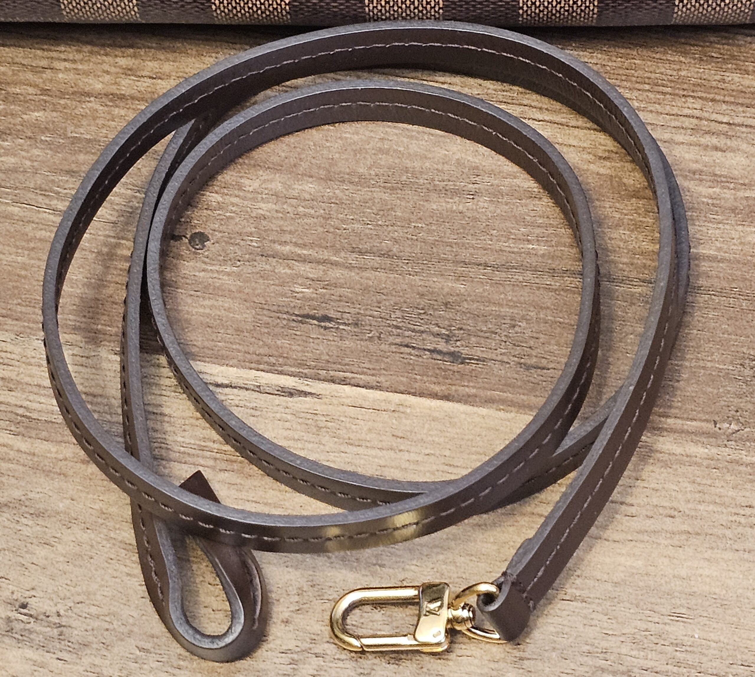 Full length of the brown leather strap with gold-tone snap hooks