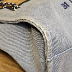 Close view of the navy sequin 31 lettering on the washed blue denim
