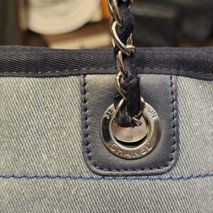 Woven leather and chain strap threaded through the stamped grommet
