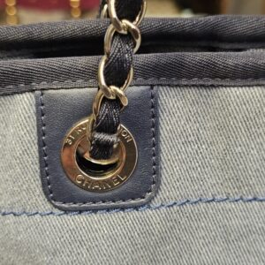 Chain strap anchored to the denim body at the stamped grommet
