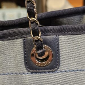 Close view of a stamped grommet and the leather woven chain strap