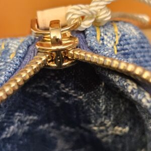 Top zip of the denim pouch with the dust bag drawstring behind