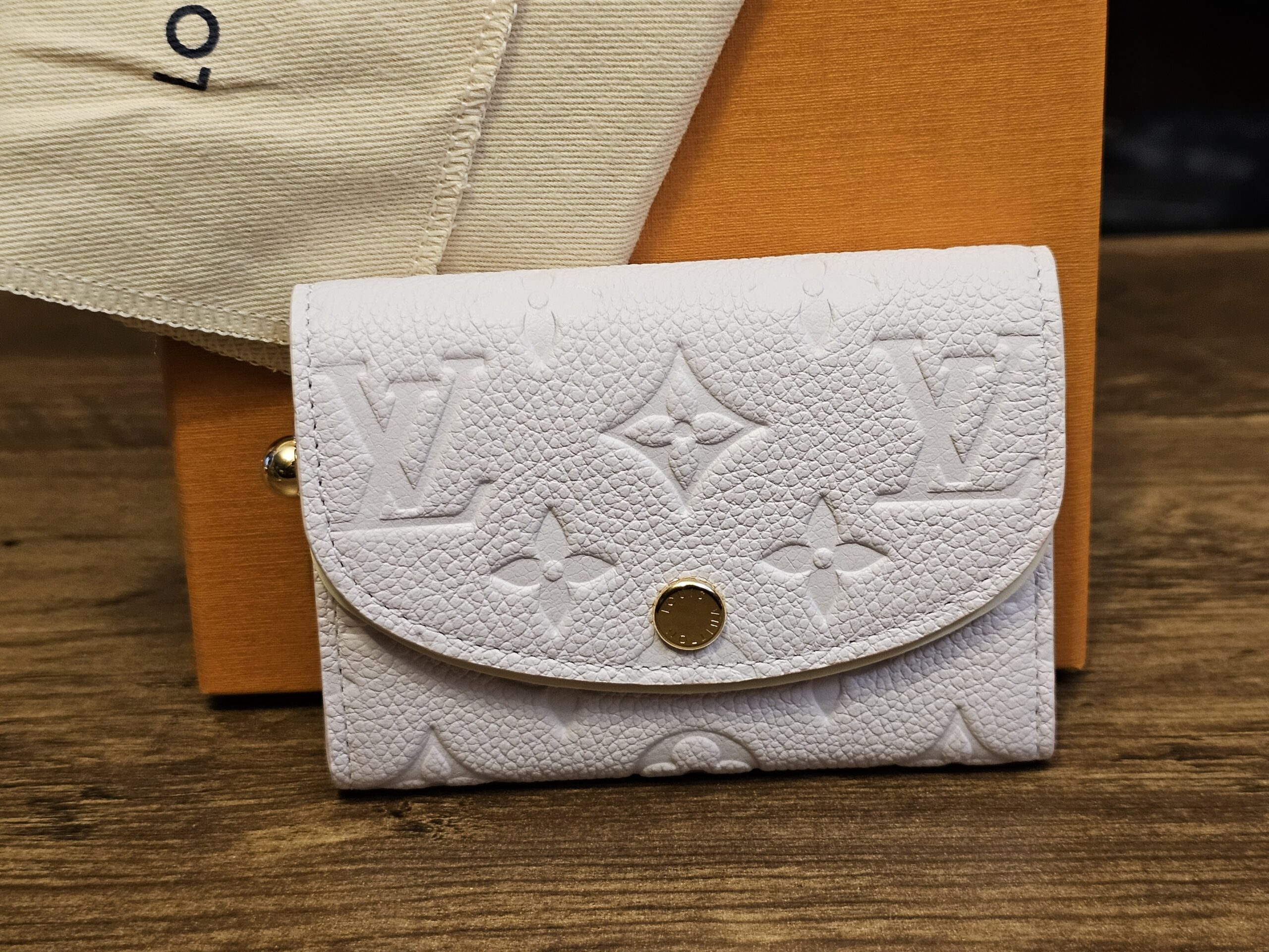 Louis Vuitton Monogram Empreinte Rosalie Coin Purse Sweet Lavender shown front on with the embossed Monogram and snap closure