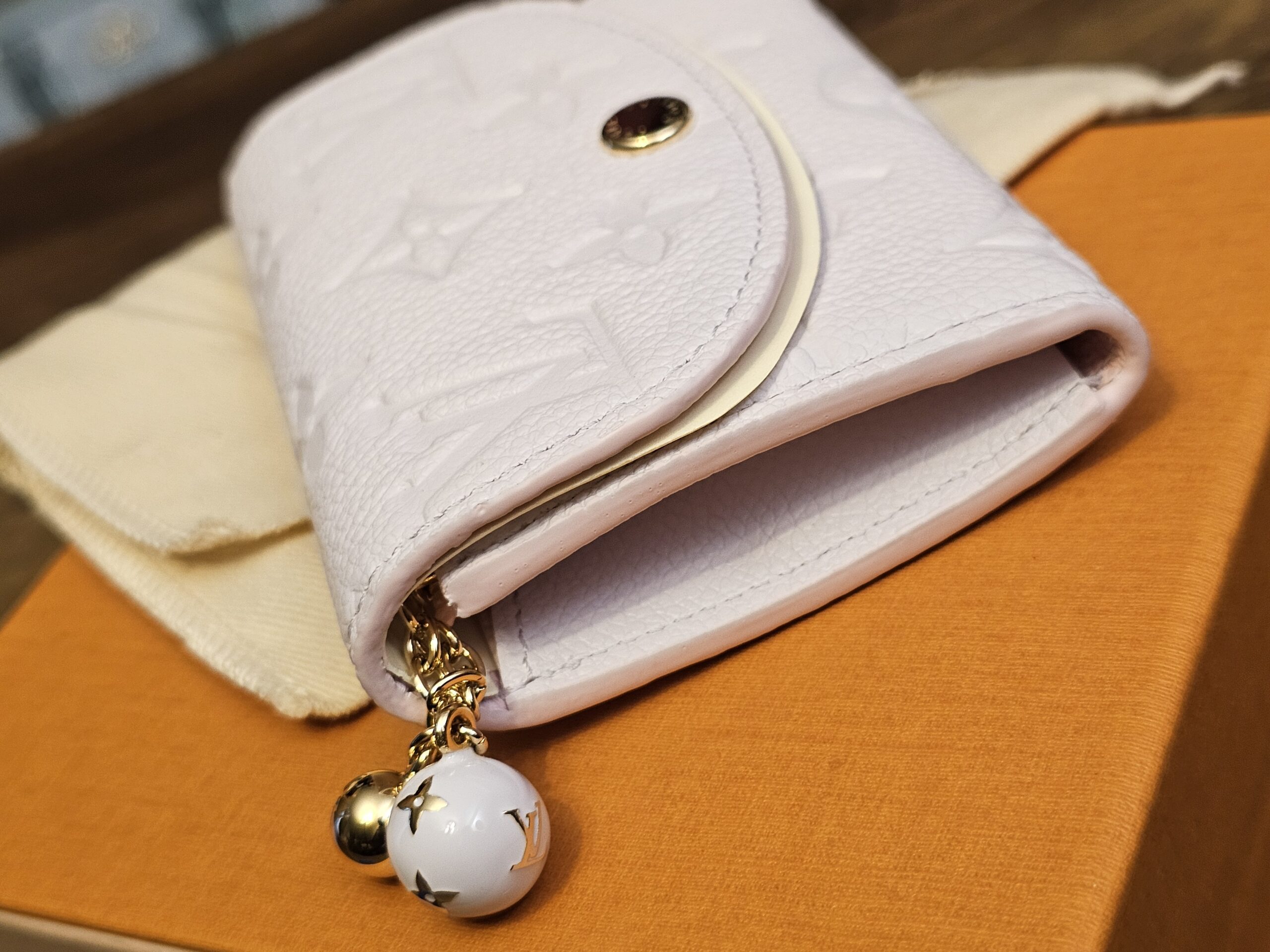 Side of the Rosalie coin purse with the enamel Monogram flower charm on the zip pull