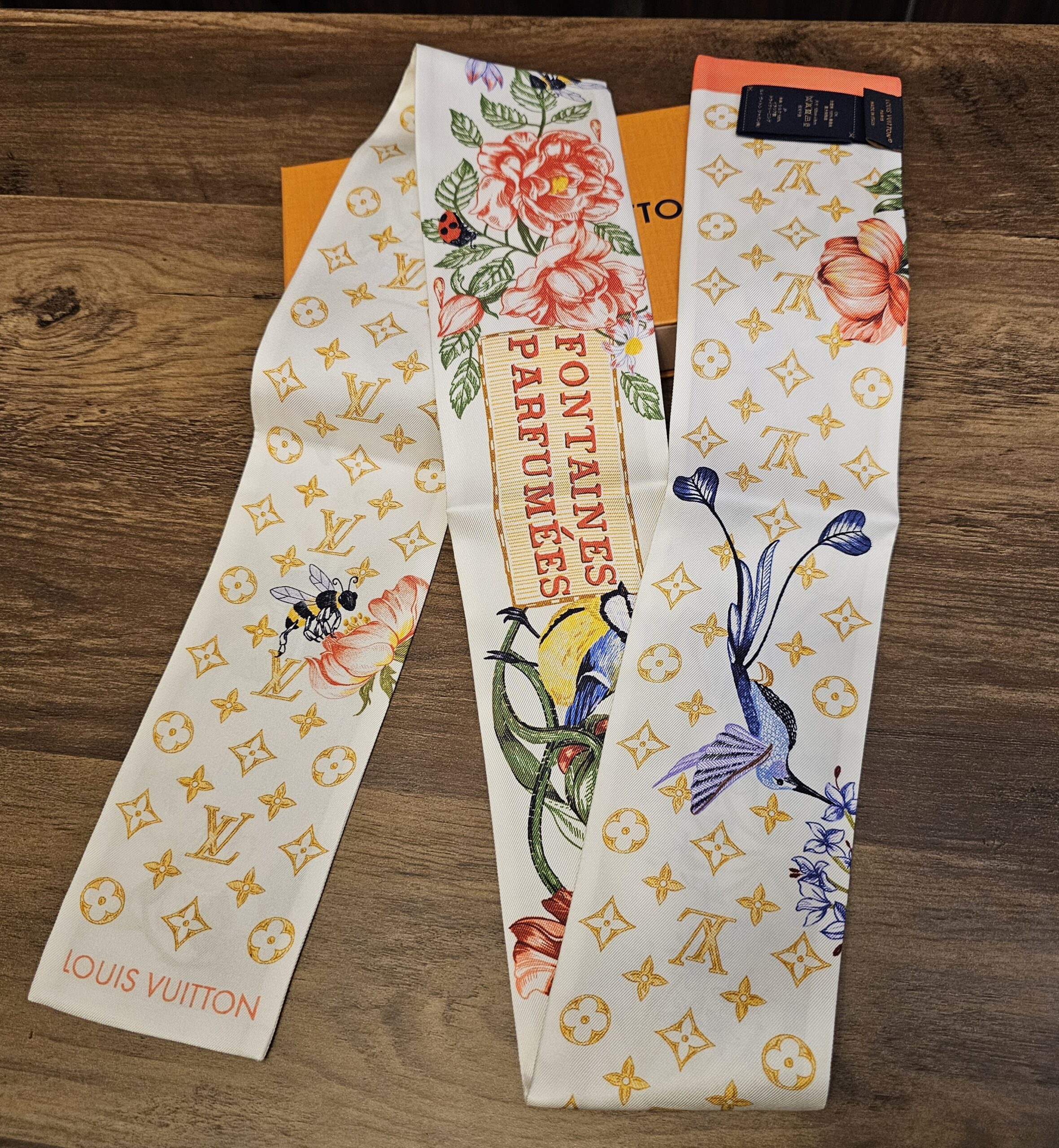FONTAINES PARFUMEES lettering panel on the silk bandeau beside roses and irises