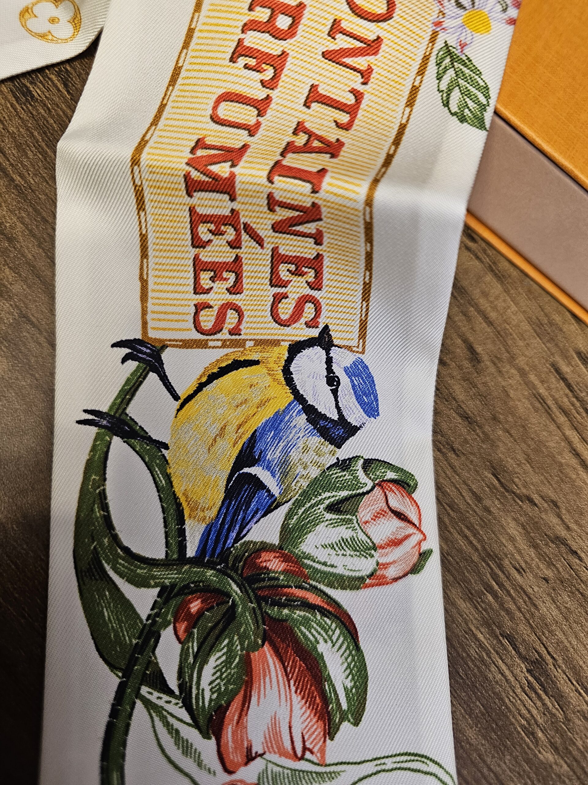 Close view of the lettering with a bird and tulips printed on the silk