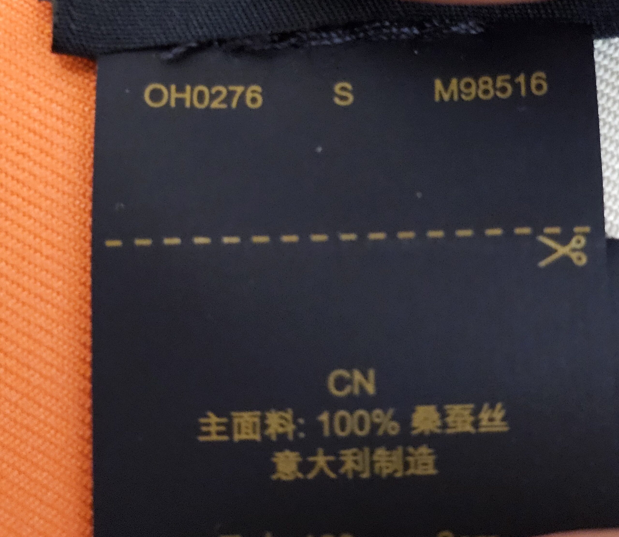 Reverse of the care label showing style code M98516 and 100 percent silk