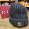 Gucci Interlocking G Ribbed Knit Beanie Black standing beside the Gucci box, showing the gold Interlocking G patch