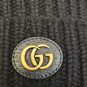 Close up of the gold-tone Interlocking G logo patch on the black knit