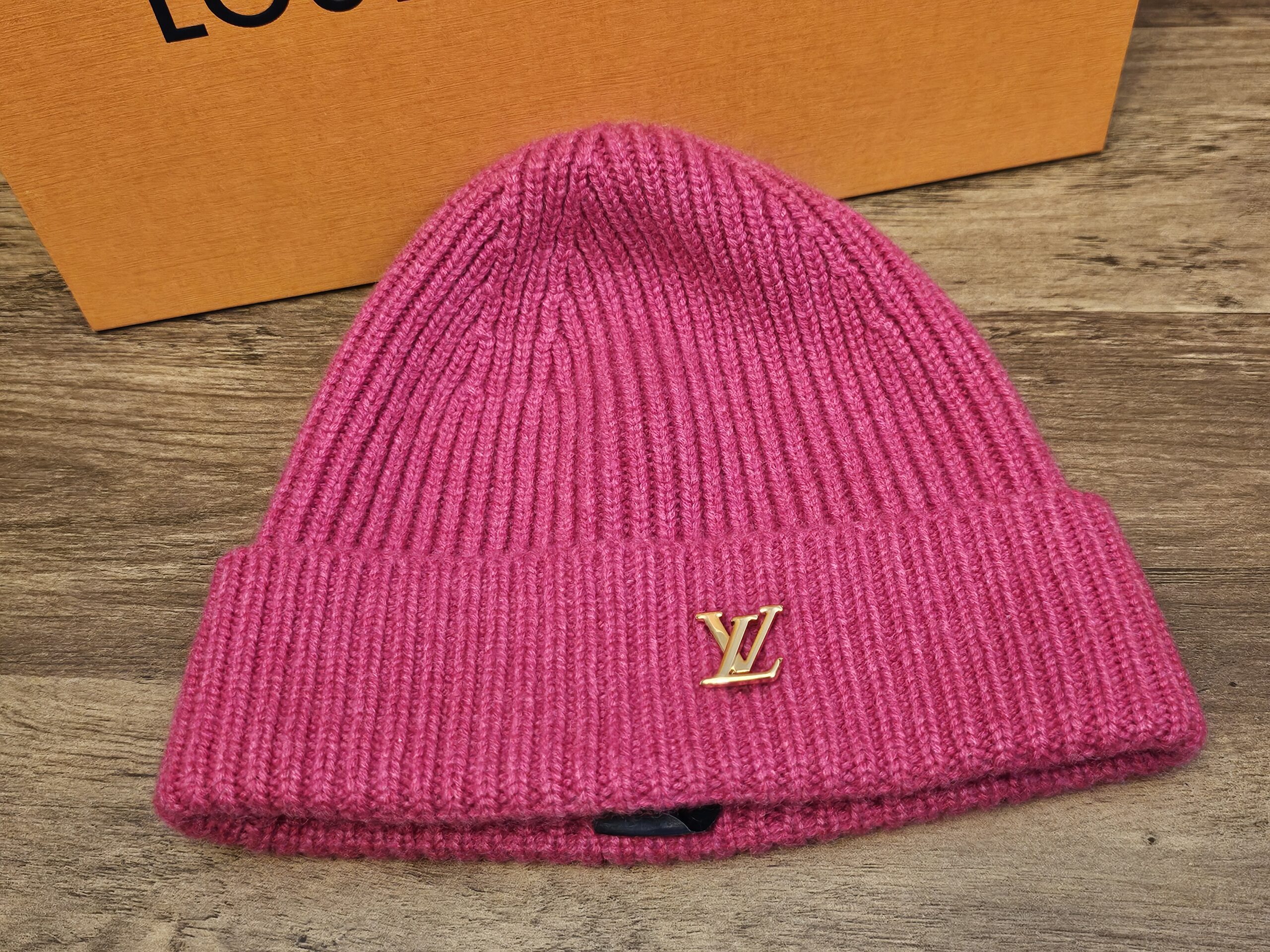 Louis Vuitton Spark Cashmere Beanie Fuchsia Pink shown front on with the gold tone LV logo on the folded cuff