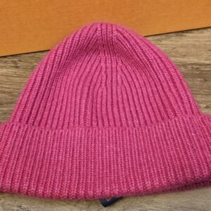 Fuchsia pink ribbed cashmere beanie laid flat on the Louis Vuitton box
