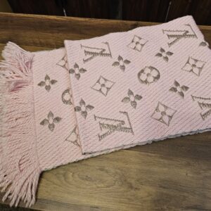 Pink Logomania Shine scarf folded showing the woven Monogram pattern and fringed ends