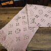 Louis Vuitton Logomania Shine Wool Scarf Pink folded on a wood table showing the metallic Monogram and fringe