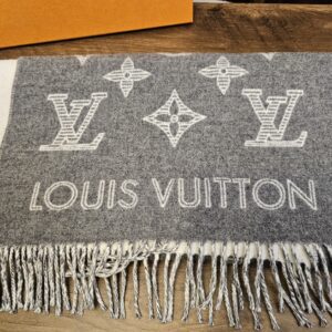 Gray Monogram Shadow scarf folded showing the oversized Louis Vuitton lettering and fringe