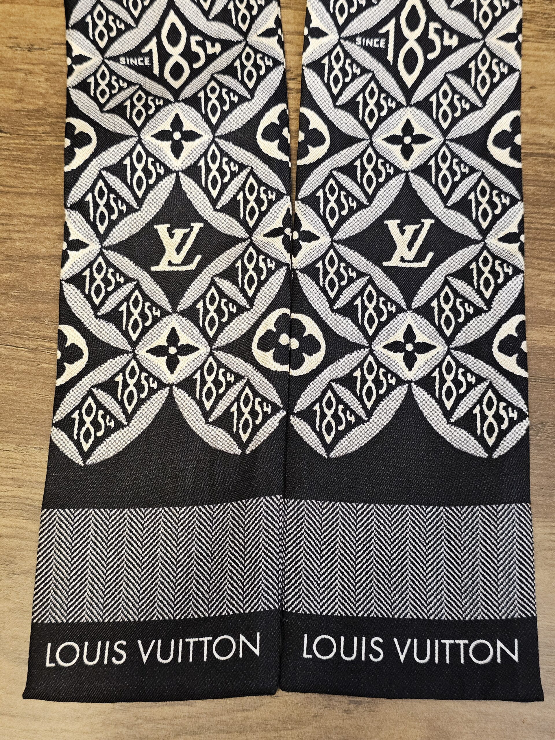 Both ends of the bandeau showing the woven Louis Vuitton lettering