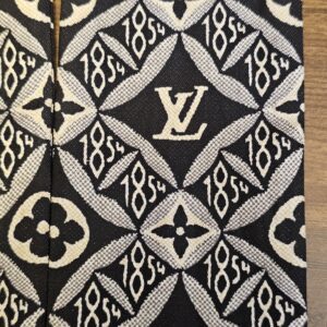 Close up of the LV monogram mixed with the 1854 motif on the silk bandeau