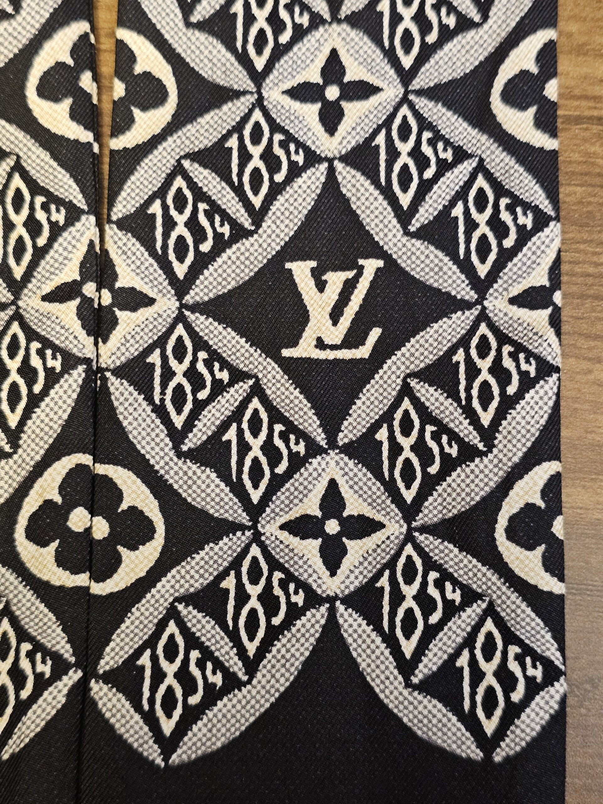 Close up of the LV monogram mixed with the 1854 motif on the silk bandeau
