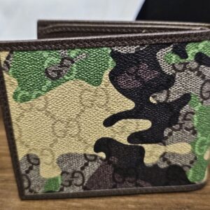 Gucci camouflage bifold wallet closed and angled on white tissue