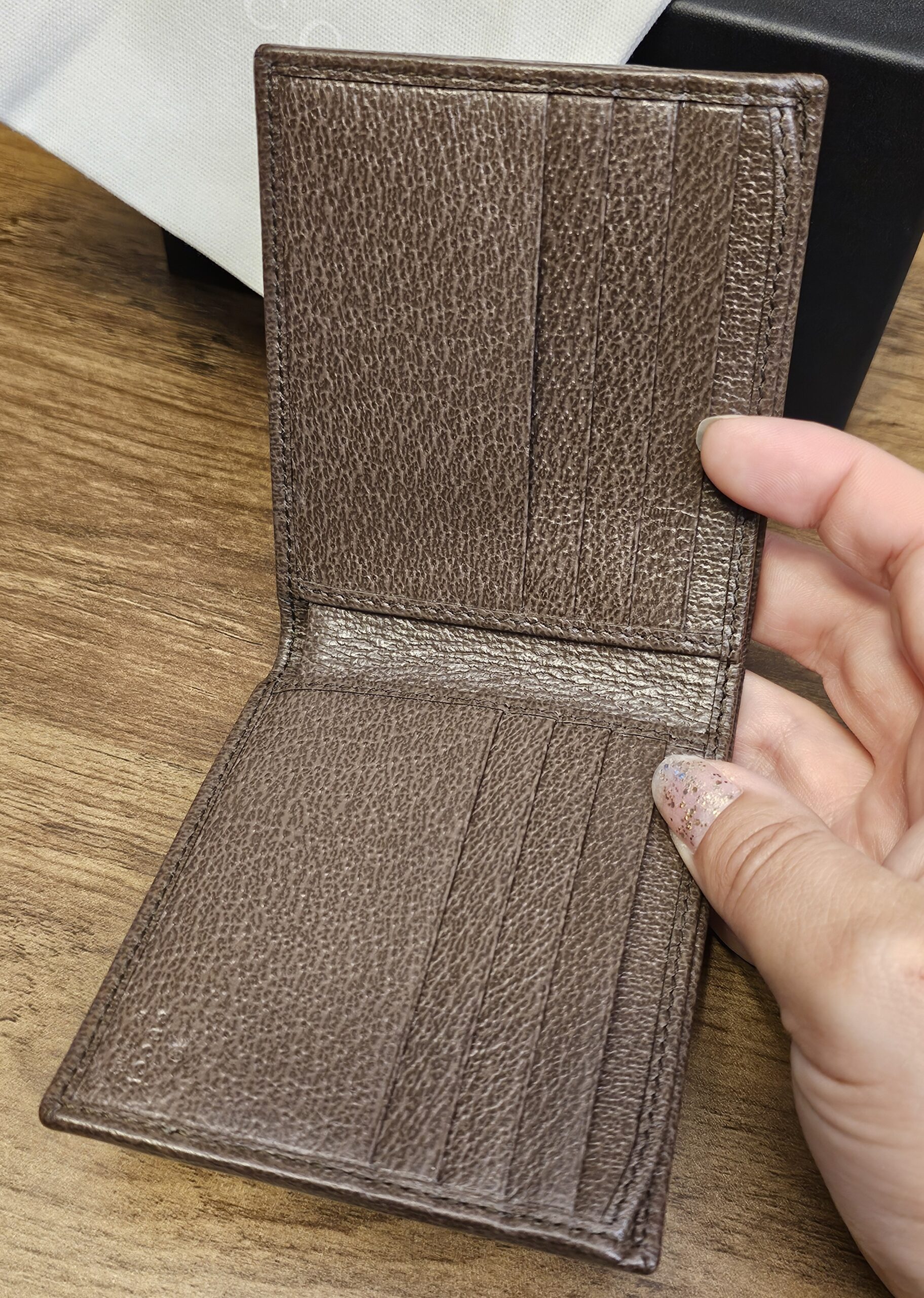 Gucci wallet opened to show the brown leather card slots and interior