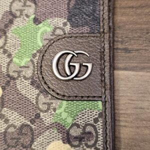 Close up of the silver-tone Double G hardware against the camouflage GG Supreme canvas