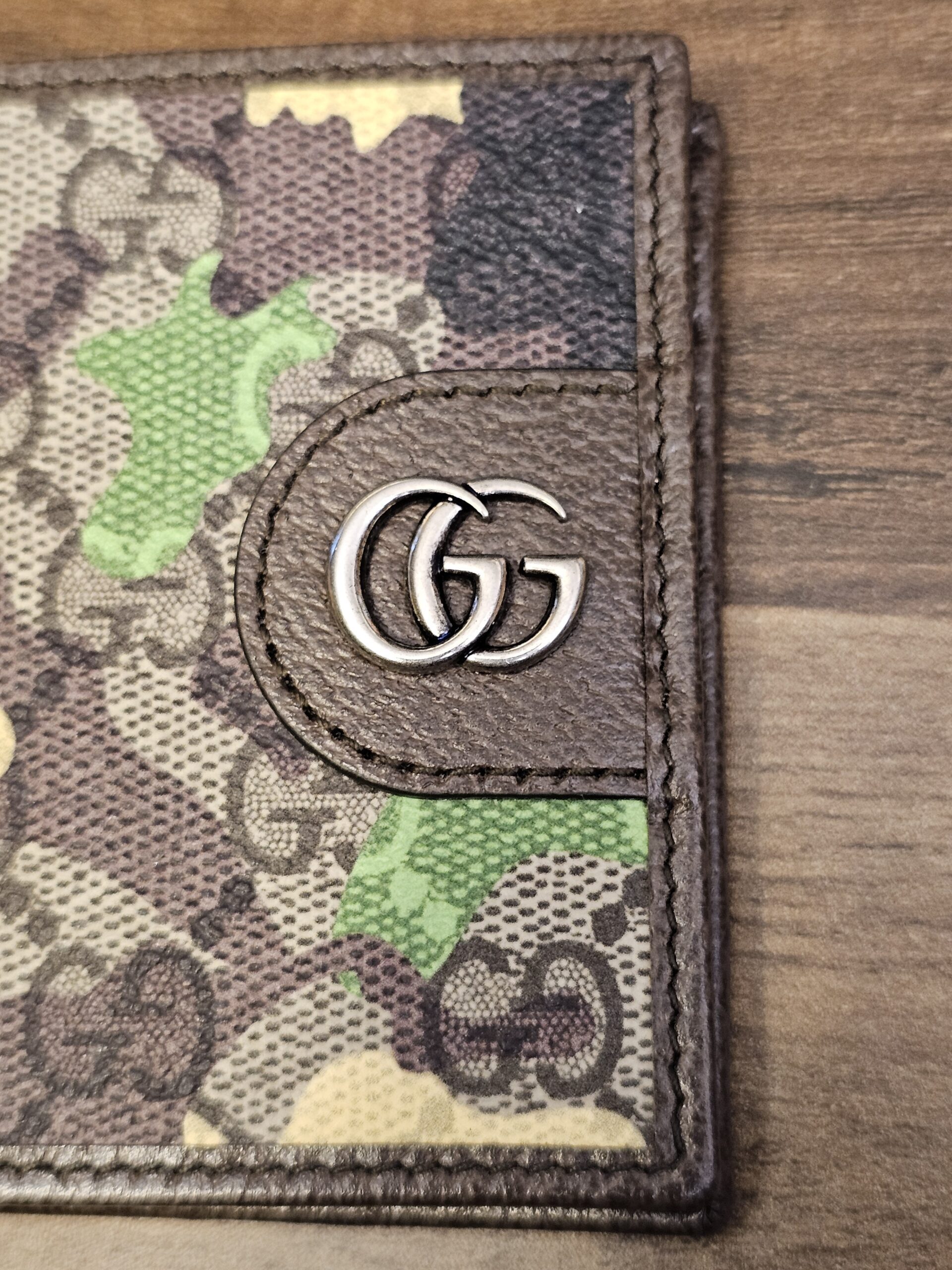 Close up of the silver-tone Double G hardware against the camouflage GG Supreme canvas