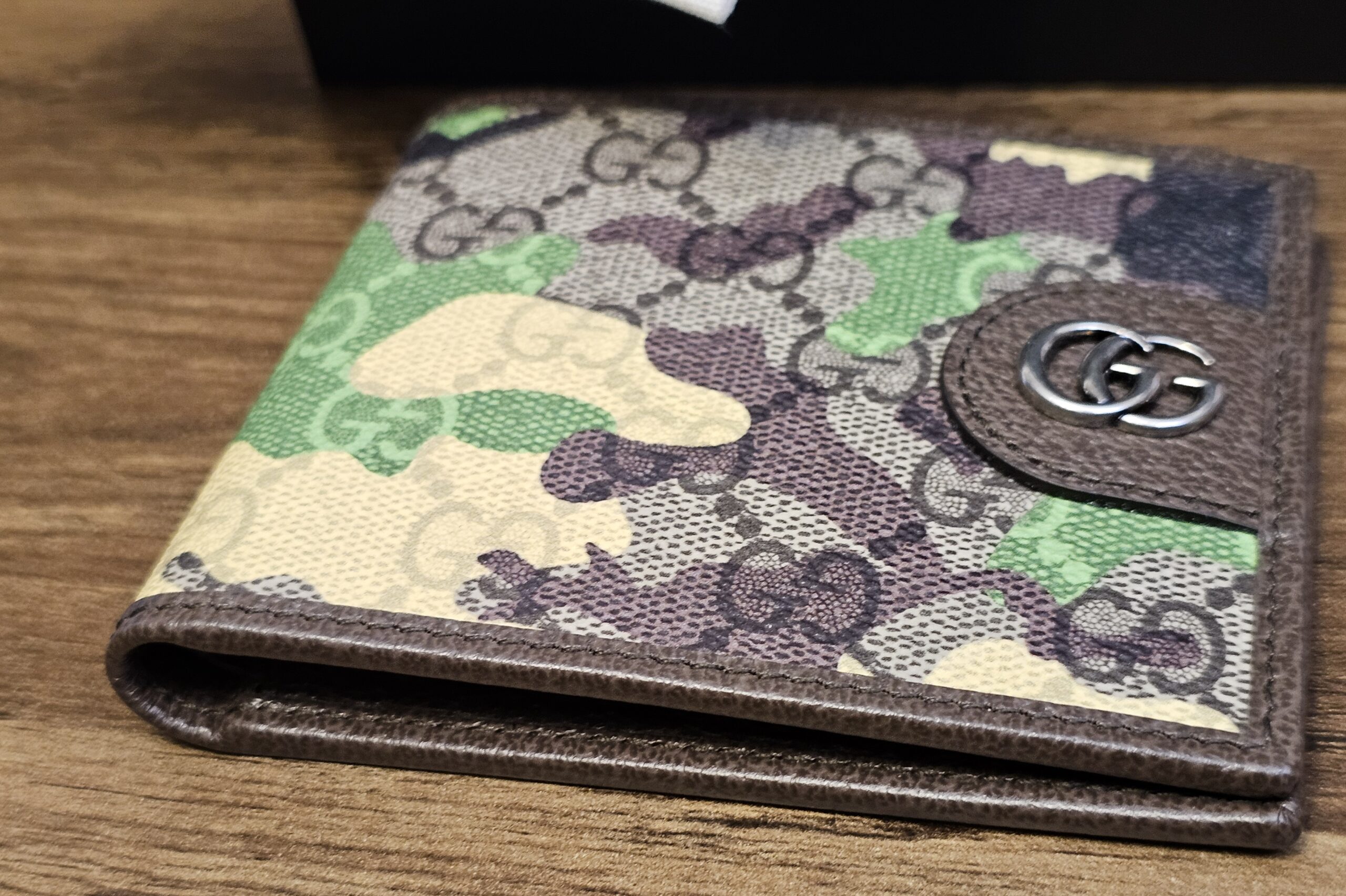 Gucci camouflage bifold wallet angled to show the GG Supreme print