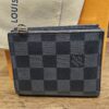 Louis Vuitton Damier Graphite Smart Wallet closed on its dust bag, showing the graphite check canvas and zip pull