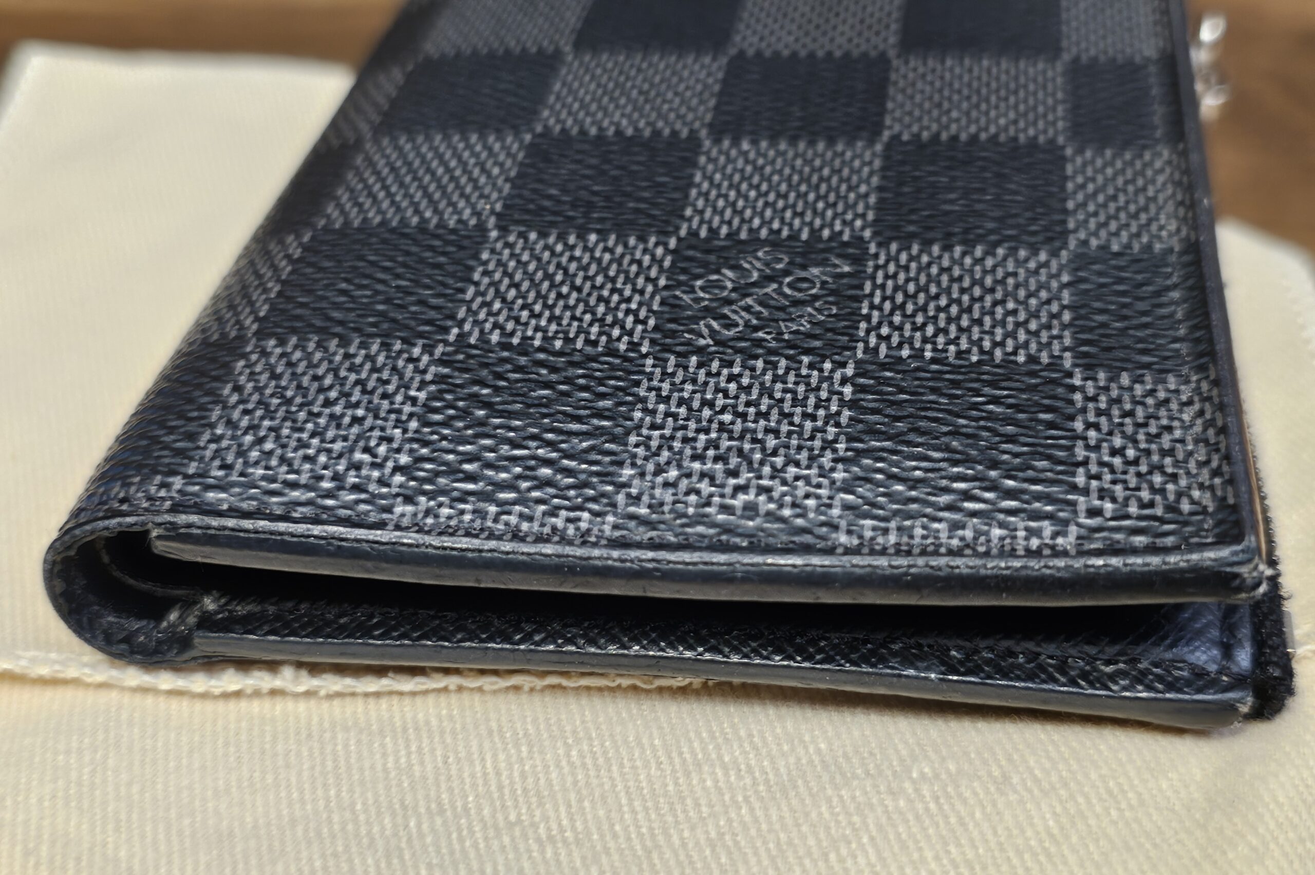 Back of the Damier Graphite Smart Wallet on the dust bag