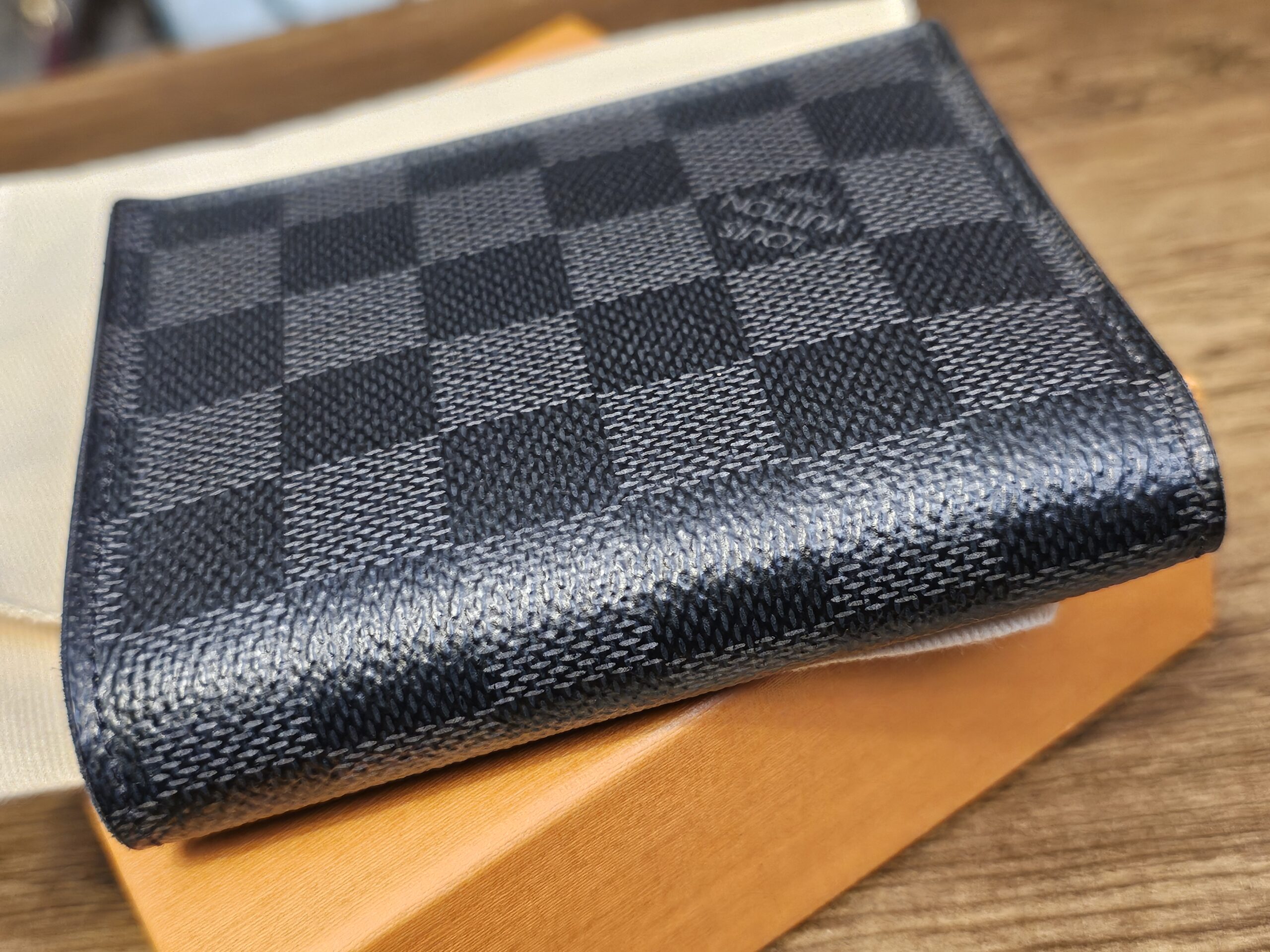 Smart Wallet resting closed on the Louis Vuitton box