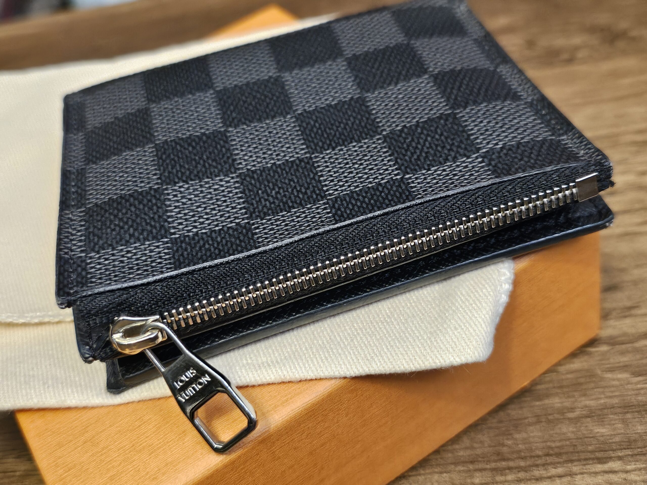 Smart Wallet on the box showing the zippered coin compartment along the edge