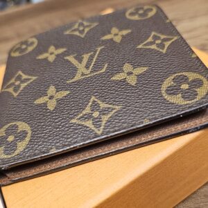 Monogram canvas wallet resting closed on the Louis Vuitton box