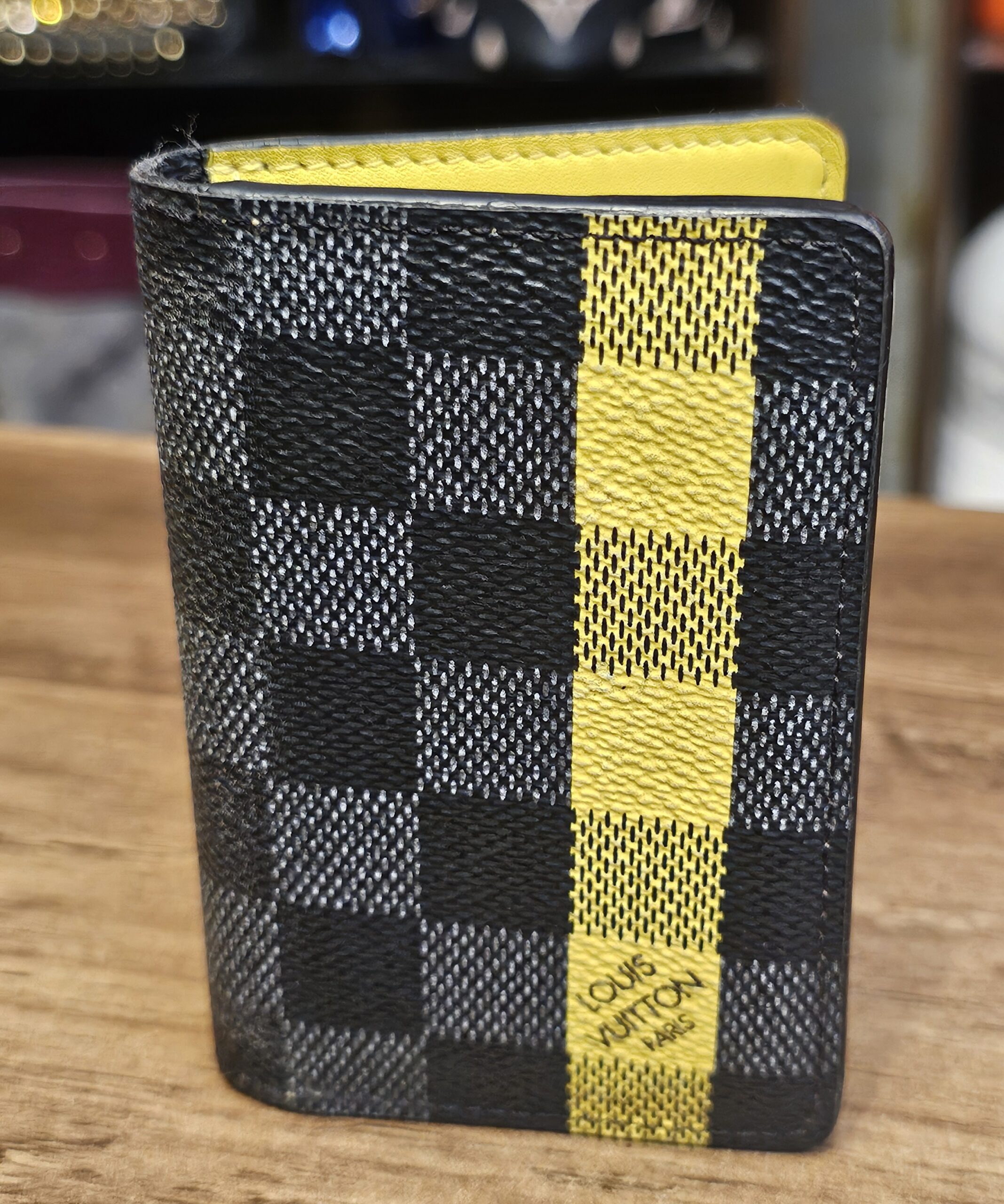 Louis Vuitton Damier Graphite Pocket Organizer Yellow Limited Edition closed, showing the yellow stripe on Damier Graphite canvas