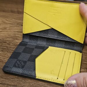 Pocket organizer opened to show the yellow leather card slots and pockets