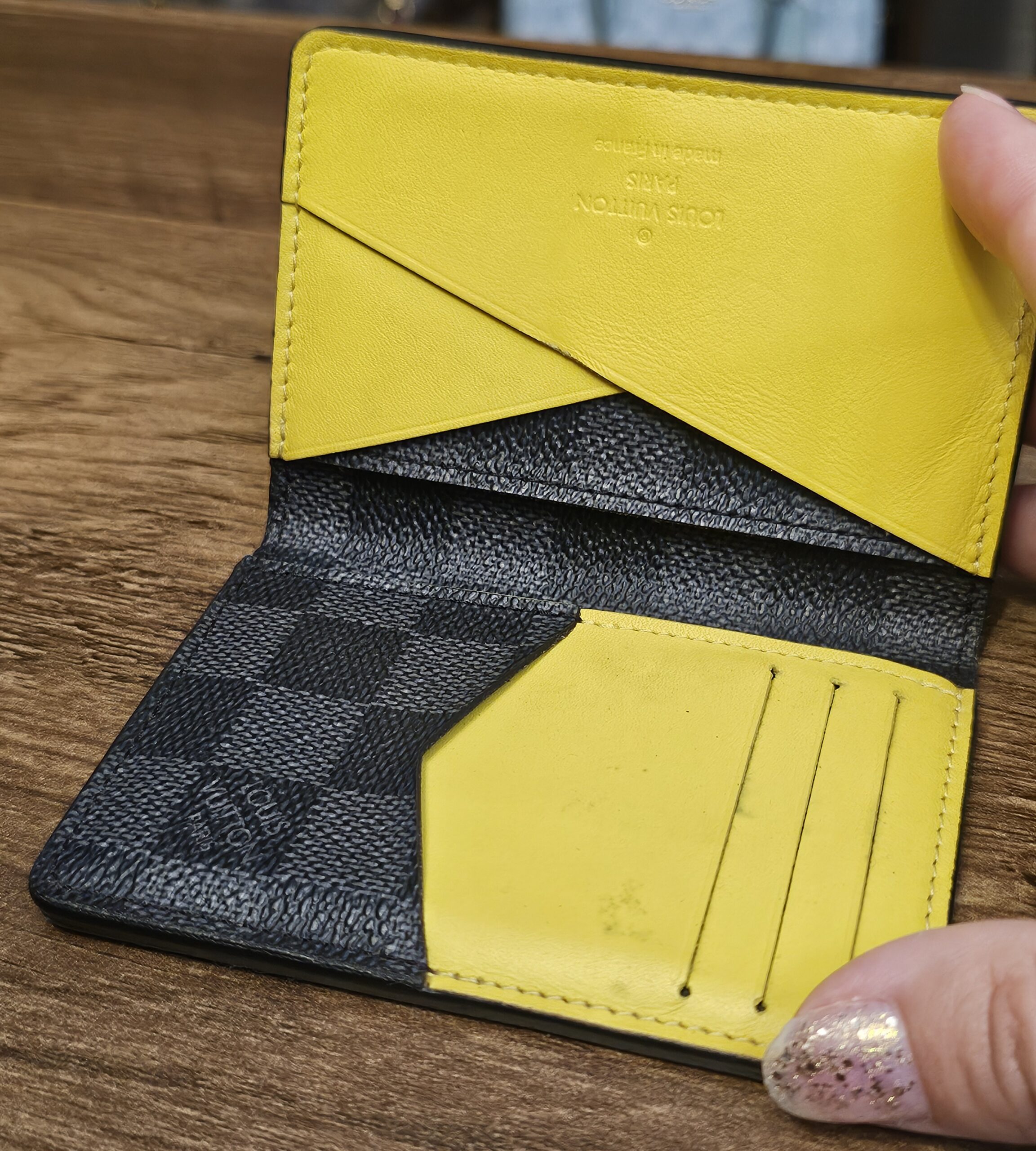 Pocket organizer opened to show the yellow leather card slots and pockets