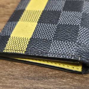 Close up of the yellow stripe running across the Damier Graphite canvas