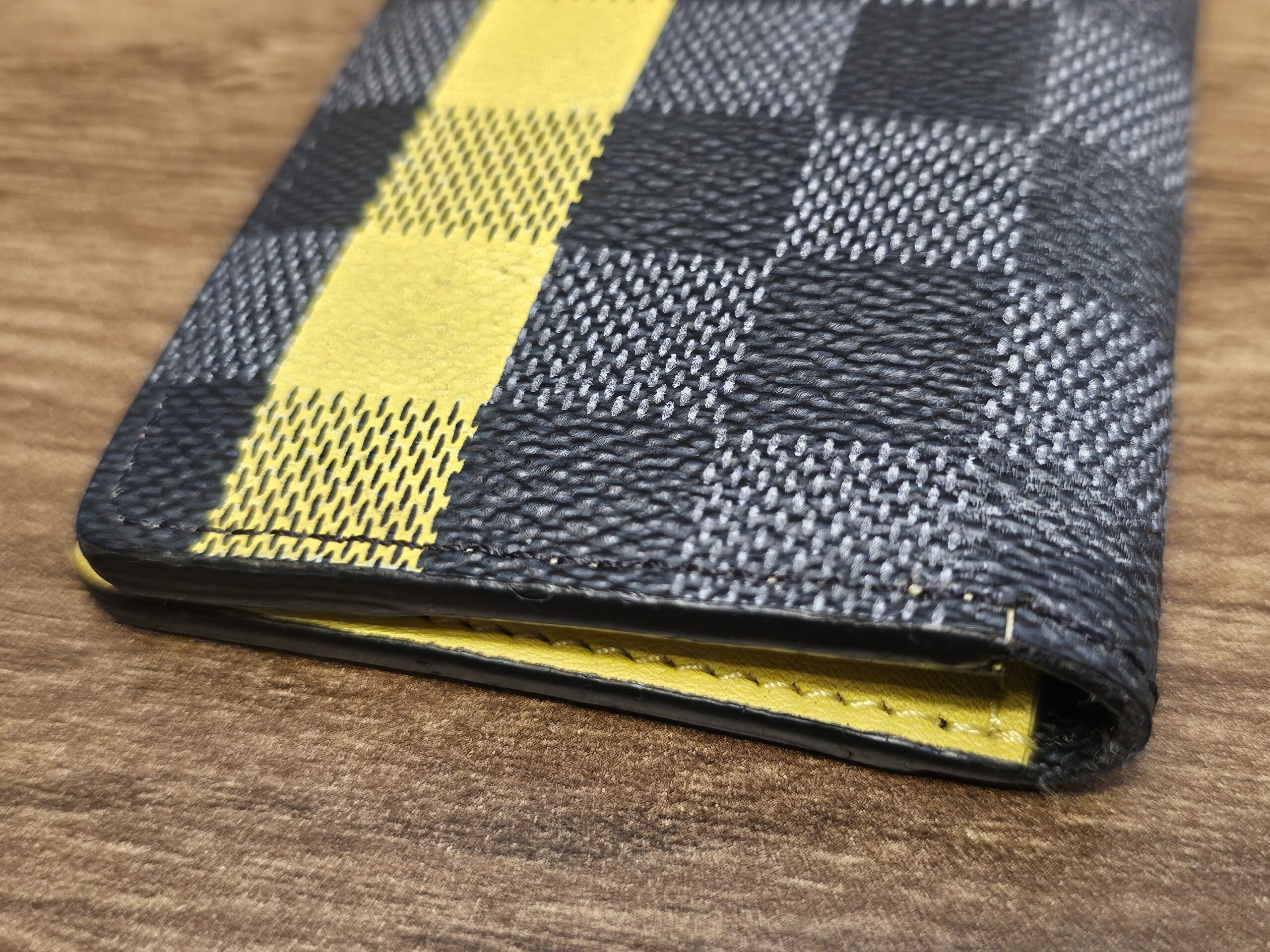 Close up of the yellow stripe running across the Damier Graphite canvas