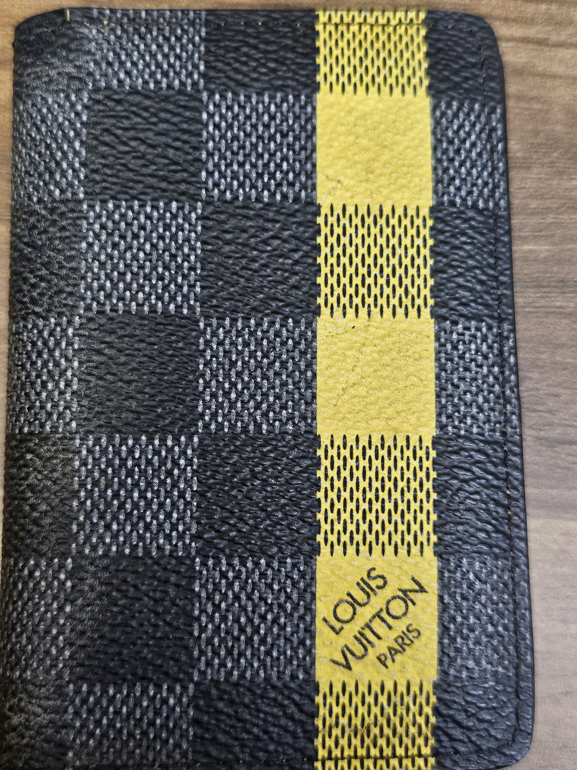 Edge view of the pocket organizer showing the yellow stripe and graphite check