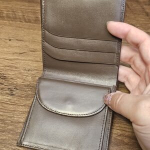 Burberrys wallet opened to show the taupe leather card slots and coin flap