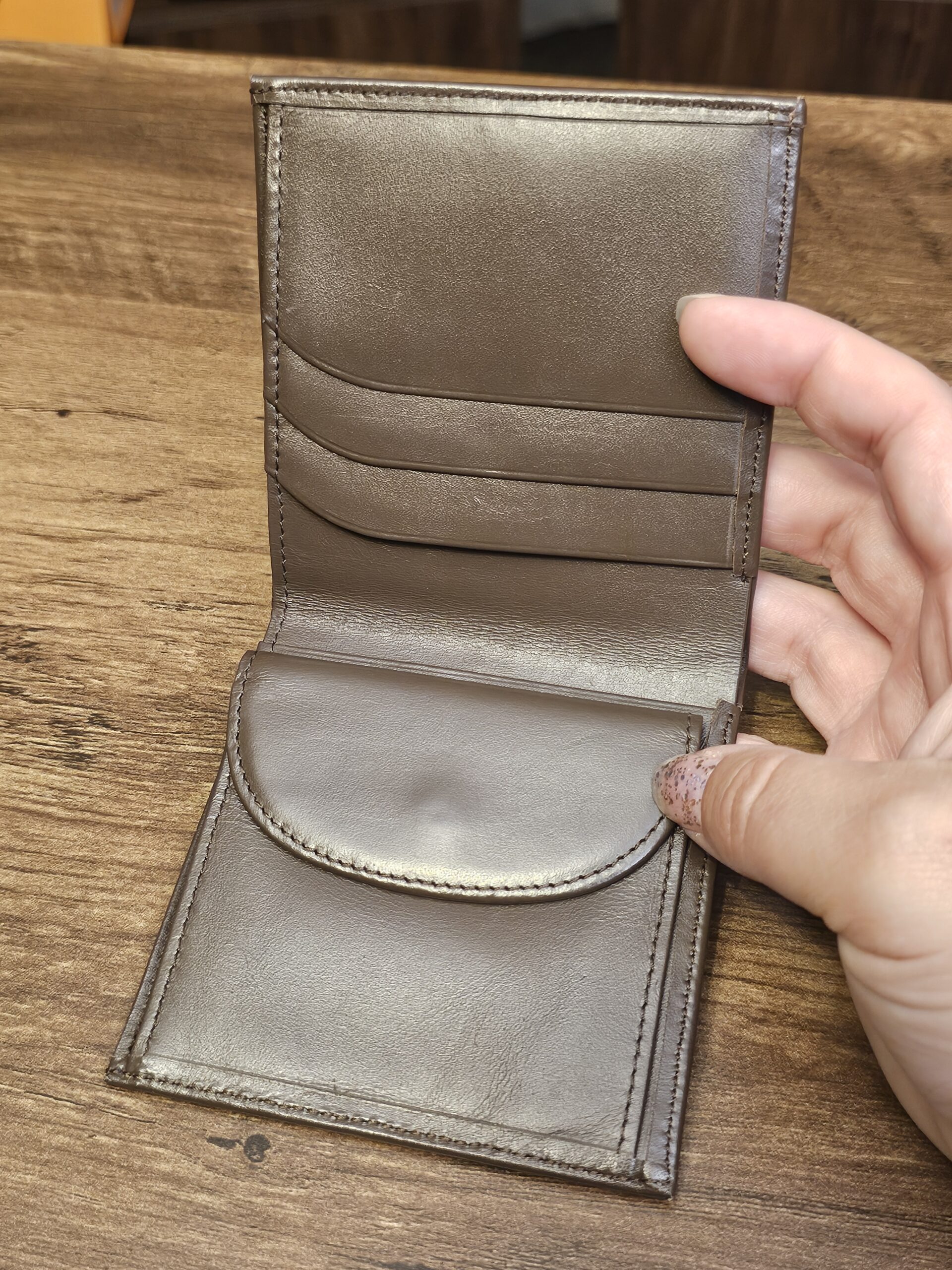 Burberrys wallet opened to show the taupe leather card slots and coin flap