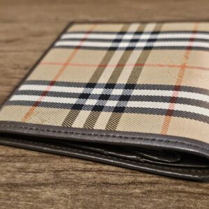 Burberrys Nova Check bifold wallet angled on a wood table
