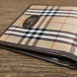 Burberrys wallet showing the camel check canvas against the dark brown leather trim