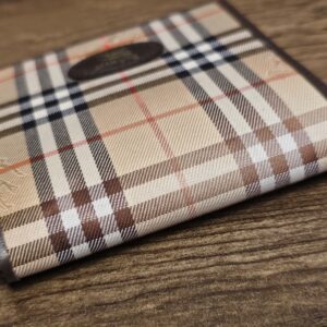 Burberrys bifold wallet standing closed with the leather logo oval in view