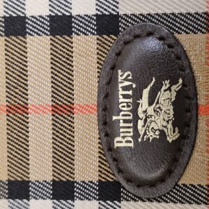 Close up of the Burberrys name and equestrian knight stamped on the leather oval