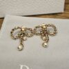 Christian Dior Gold Tone Braided Bow Pearl Drop Earrings shown as a pair on the Dior pouch